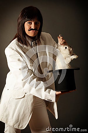 Illusionist with rabbit in black top hat Stock Photo