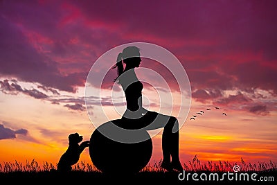 Girl does pilates at sunset with her puppy Stock Photo