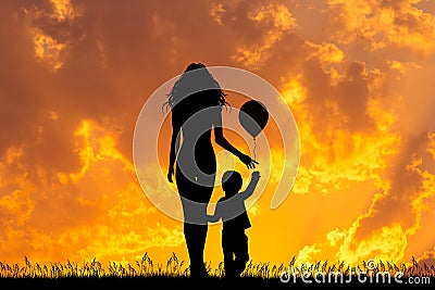 Mother and child with balloon at sunset Stock Photo