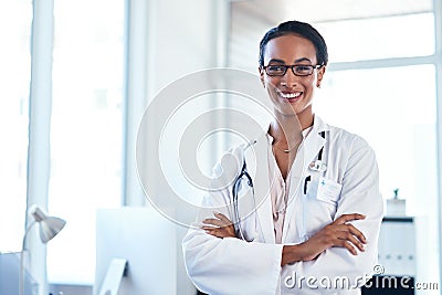 Im all about your wellness. Portrait of a confident young doctor standing in her consulting room. Stock Photo