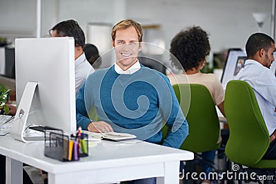 Im crushing this deadline. Portrait of a creative businessman sitting behind of his computer in the office. Stock Photo