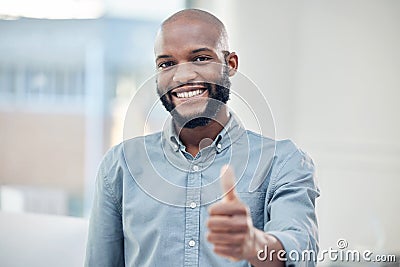 Im getting closer to success. a handsome young businessman standing alone in his office and making a thumbs up gesture. Stock Photo
