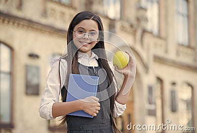 Im loving it. Happy child hold apple and book. School snack. Snack break. Healthy eating and snacking. Vegetarian food Stock Photo