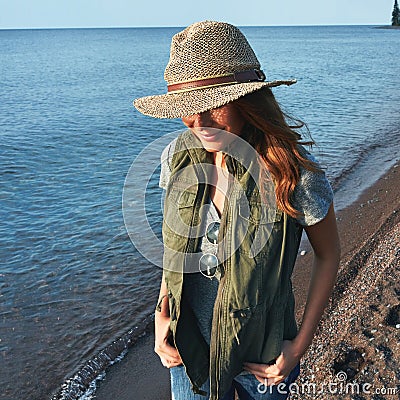 Im more of an outdoorsy kind of person. an attractive young woman enjoying a walk by the lake. Stock Photo