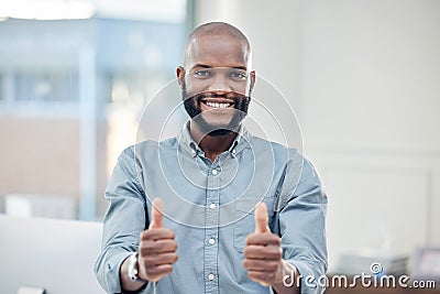Im on the right track. a handsome young businessman standing alone in his office and making a thumbs up gesture. Stock Photo