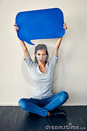 Im speaking my mind. Studio shot of an attractive young woman posing against a grey background. Stock Photo