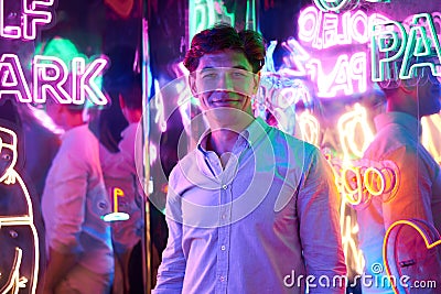 Image of an adult male in an amusement park in a room with neon light. Entertainment concept Stock Photo