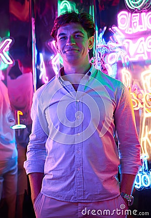 Image of an adult male in an amusement park in a room with neon light. Entertainment concept Stock Photo