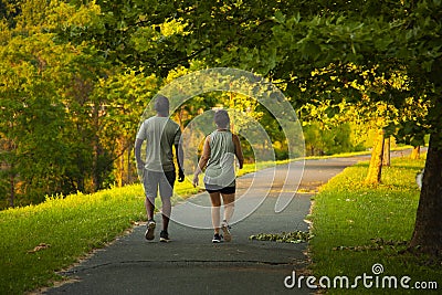 Image of an African American man and a caucasian woman walking on a hiking trail Editorial Stock Photo
