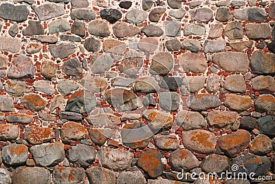 Image of an ancient wall of boulders and bricks covered with moss Stock Photo