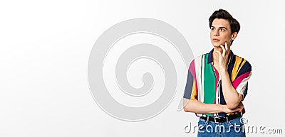 Image of angrodynous young man looking at upper left corner thoughtful, reading promo, standing over white background Stock Photo