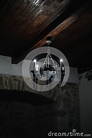 The image of an antique old iron chandelier hanging in the room. Metal chandelier in medieval Editorial Stock Photo