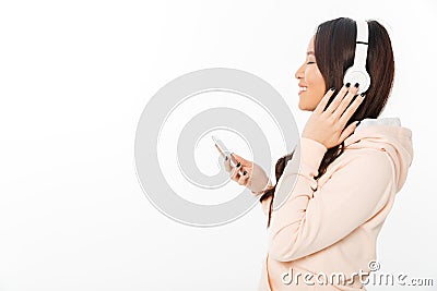 Asian cheerful woman listening music with headphones. Stock Photo