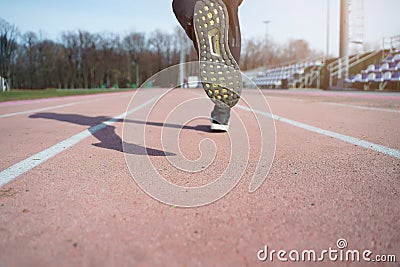 Image from back of legs of athlete running through stadium Stock Photo