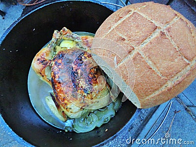 Iron Dutch Oven Cooking, Rosemary Chicken and Crusty Artisan Wheat Bread Stock Photo