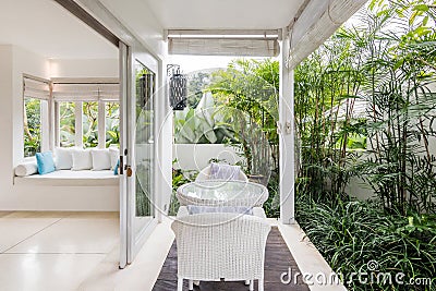 Unique patio area with wooden furniture surrounded by a garden. Stock Photo