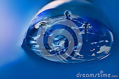 Blue surface and bubble with three pairs of water drops colliding Stock Photo