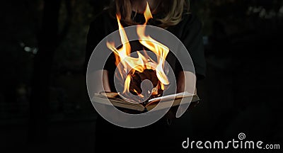 Image of book burning in woman hands in forest Stock Photo