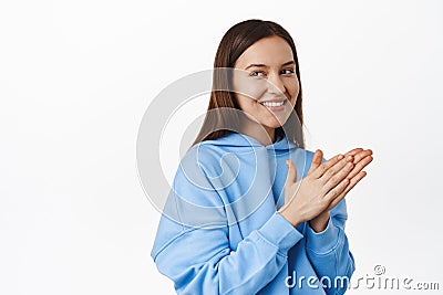 Image of brunette cunning girl rub hands, smiling and looking aside at sale banner with thoughtful, interested face Stock Photo