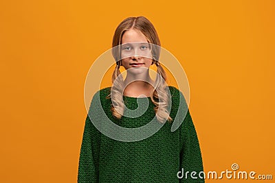 Image of charming blonde teen smiling and looking at camera. Studio shot, yellow background. Facial expression concept Stock Photo