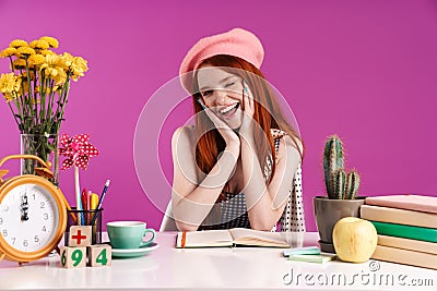 Image of charming teenage girl smiling while studying with exercise books Stock Photo