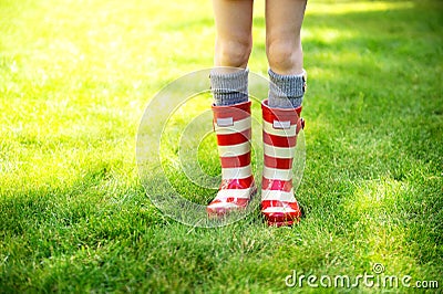 Image of child legs wearing red rain boots Stock Photo