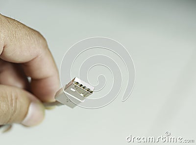 An image close-up hand hold select focus drive USB plug accessory device for connection or transfer data or charger power Stock Photo