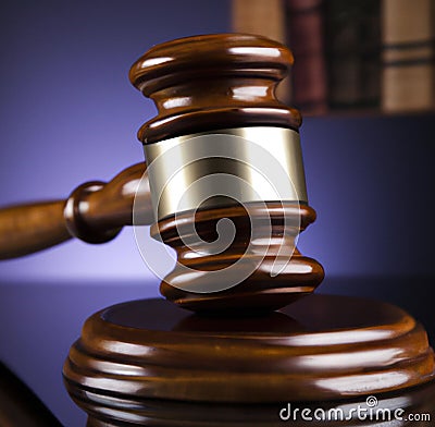 Image of close up of judge slamming gavel on purple background Stock Photo
