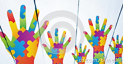 Image of colourful crayons over hands formed with puzzles Stock Photo