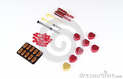 Heart shape sweet chocolate wrapped in foil and medicines Stock Photo