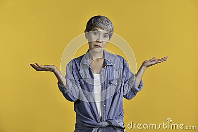 Image of confused puzzled upset middle aged Asian woman 50s standing isolated over colour background Stock Photo