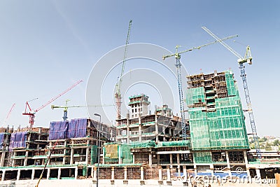 Image of construction site against blue sky with multiple tower cranes Stock Photo