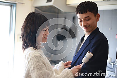 A couple removing dust from clothing with adhesive tape Stock Photo