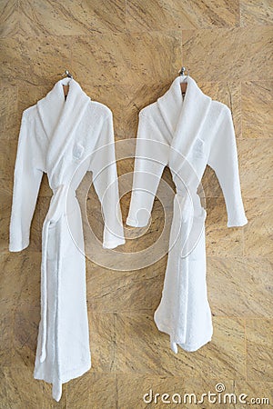 The image of couple white bathrobes on a hanger in bathroom. Stock Photo