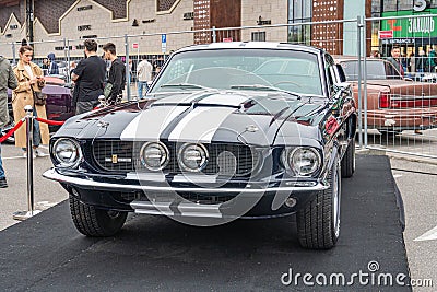 Image of a customized muscle car on display at an automotive event, showcasing a two-tone color scheme and modifications Editorial Stock Photo
