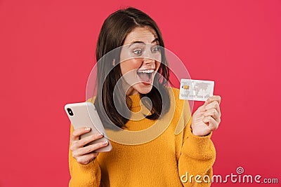 Image of delighted caucasian girl posing with cellphone and credit card Stock Photo