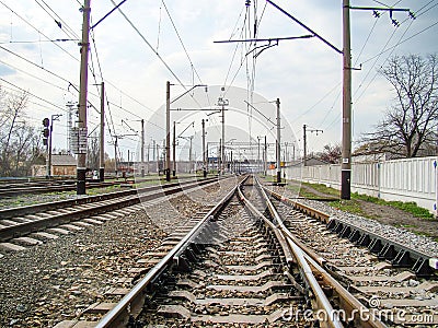Image depicts a railway junction or switching area with multiple tracks merging, under an overcast sky Electric train Editorial Stock Photo