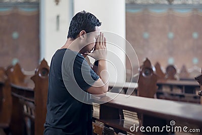 Devout man praying in the church Stock Photo