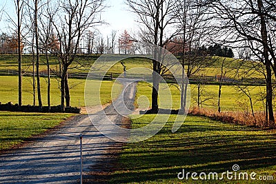 Dirt road in hills and valleys with stonewalls and sunshine. Stock Photo