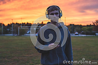 Lonely teenager listening to music at sunset. Stock Photo