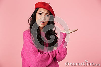 Image of displeased beautiful asian girl holding copyspace at her hand Stock Photo