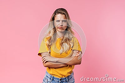 Image of displeased blonde girl posing with hands crossed Stock Photo
