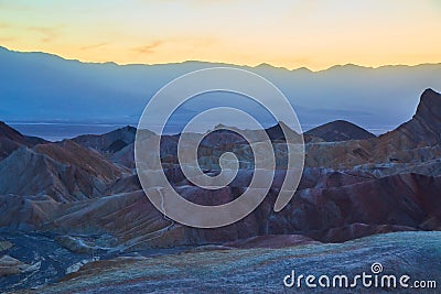 Dusk golden light hitting colorful mountains in Death Valley Stock Photo