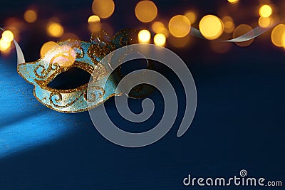 Image of elegant blue and gold venetian, mardi gras mask over blue background. Stock Photo