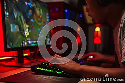 Image of excited asian teenage gamer boy playing video games on Stock Photo