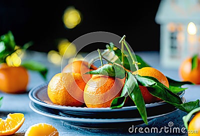 Ripe Tangerines on Textured grey plates with Festive Lights Stock Photo