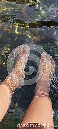 Image of feet soaking in clear river water Stock Photo