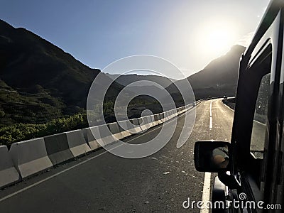 The image in front of the sports car scene behind as the sun going down with wind turbines in the back Stock Photo