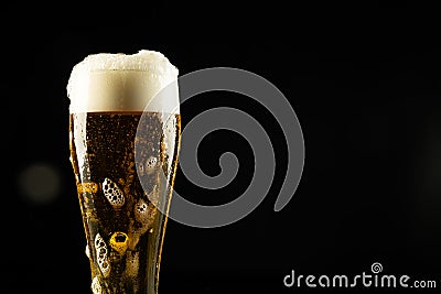 Image of full pint glass of foamy beer, with copy space on black background Stock Photo