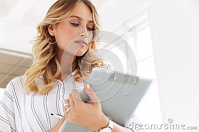 Image of gorgeous elegant secretary woman holding clipboard in office Stock Photo